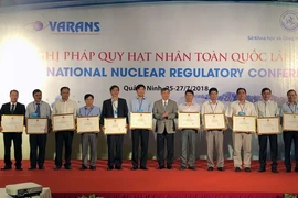Đại diện Bộ Khoa học và Công nghệ tặng Bằng khen và Kỷ niệm chương cho các cá nhân, tập thể có thành tích xuất sắc trong công tác bảo đảm an toàn bức xạ và hạt nhân. (Ảnh: Nguyễn Hoàng/TTXVN)