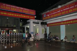 Phóng viên các cơ quan thông tấn, báo chí tác nghiệp trước cổng Sở Giáo dục và Đào tạo Sơn La. (Ảnh: Hữu Quyết/TTXVN)