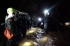 Lực lượng cứu hộ chuyển thiết bị vào hang Tham Luang trong chiến dịch giải cứu các thành viên đội bóng. (Nguồn: EPA/TTXVN)