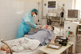 Bác sỹ chăm sóc và điều trị cho một bệnh nhân. (Ảnh: TTXVN)