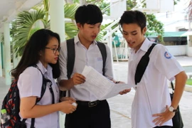 Các thí sinh tập trung trao đổi kết quả sau khi rời khỏi phòng thi. (Ảnh: Phan Sáu/TTXVN)
