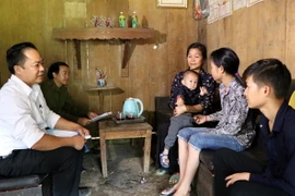 Chính quyền xã Thèn Sin, huyện Tam Đường (Lai Châu) gặp những người xuất cảnh trái phép để nắm thông tin. (Ảnh: Việt Hoàng/TTXVN)