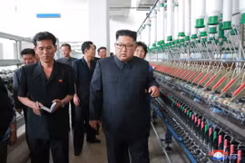 Nhà lãnh đạo Triều Tiên (phải) thăm nhà máy dệt ở Sinuiju. (Ảnh: Yonhap/TTXVN)
