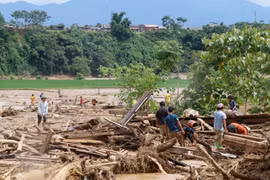 Người dân đang tích cực thu dọn khắc phục hậu quả do mưa lũ tàn phá. (Ảnh: Việt Dũng/TTXVN)
