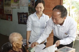 Phó Chủ tịch Ủy ban Mặt trận Tổ quốc Thành phố Hồ Chí Minh Trần Tấn Hùng trao quà cho Mẹ Việt Nam Anh hùng Bùi Thị Diệp. (Ảnh: Hoàng Hải/TTXVN)