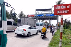 Các phương tiện dừng xe tại trạm BOT T1 để phản ứng việc trạm chưa thực hiện giảm giá theo quy định. (Ảnh: Thanh Liêm/TTXVN)