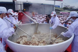 Các chuyên gia ẩm thực và nghệ nhân đang thực hiện quy trình nấu phở. (Ảnh: Mỹ Phương/TTXVN)