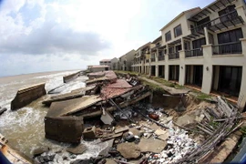 Bờ kè tại các resort bị sạt lở do sóng biển xâm thực những ngày qua tại biển Cửa Đại. (Ảnh: Trần Lê Lâm/TTXVN)