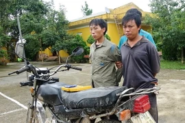 Hai đối tượng cùng tang vật sau khi bị bắt. (Ảnh: Xuân Tư/TTXVN)