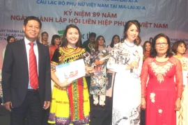 Hai thí sinh (đứng giữa) đoạt giải cao nhất cuộc thi. (Ảnh: Hoàng Nhương/Vietnam+)