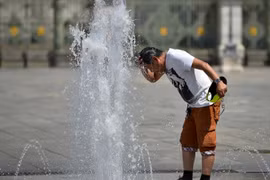 Một người đàn ông giải nhiệt bằng nước. (Nguồn: Getty Images)