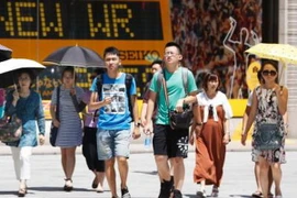 Người dân Nhật Bản dùng ô tránh nắng khi di chuyển trên đường phố Tokyo ngày 9/8. (Nguồn: Kyodo/TTXVN)