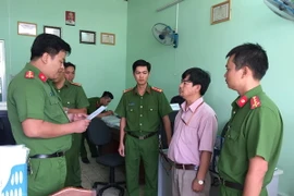 Công an thành phố Cần Thơ đọc lệnh bắt ông Trần Tuấn Kiệt. (Ảnh: Thanh Sang/TTXVN)