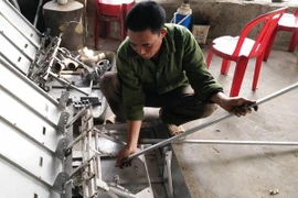 Nông dân Vũ Văn Dung hướng dẫn sử dụng máy cấy. (Ảnh: Hải Yến/TTXVN)