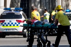 Hỗ trợ người bị thương tại hiện trường vụ tấn công bằng xe tải ở Las Ramblas ngày 17/8. (Nguồn: EPA/ TTXVN)