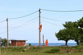 Sửa chữa lưới điện hạ thế trên đảo Cồn Cỏ. (Ảnh: Ngọc Hà/TTXVN)