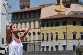 Khách du lịch làm mát bằng vòi nước công cộng khi nhiệt độ lên tới 40 độ C tại Florence, Italy ngày 1/8. (Nguồn: EPA/TTXVN)