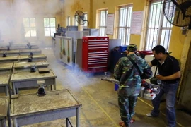 Nhân viên y tế quận Đống Đa phun thuốc tại các lớp học của Trường CĐ Nghề Công ngiệp Hà Nội (131 Thái Thịnh). (Ảnh: Thành Đạt/TTXVN)