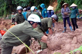 Huyện Ba Chẽ chẽ huy động nhân lực, phương tiện để xây dựng ngầm tạm bằng rọ đá tại thay thế cầu Cổ Ngựa bị sập đổ trong lũ. (Ảnh: Văn Đức/TTXVN)