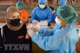 Nhân viên y tế tiêm chủng vaccine ngừa COVID-19. (Ảnh: AFP/TTXVN)