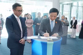Phó Chủ tịch Quốc hội Nguyễn Khắc Định (bên phải) lưu bút tại trường Đại học Quốc gia Brunei. (Ảnh: Hằng Linh/ TTXVN)
