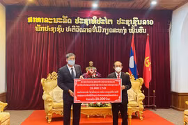 Đồng chí Nguyễn Đăng Hùng, Tổng Lãnh sự quán Việt Nam tại Luang Prabang (bên trái), trao tượng trưng quà của Đảng bộ, Chính quyền và Nhân dân Thủ đô Hà Nội tặng tỉnh Luang Prabang. (Ảnh: Tổng Lãnh sự quán Việt Nam tại Luang Prabang cung cấp)
