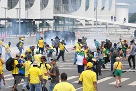 Lực lượng an ninh Brazil nỗ lực ngăn người biểu tình ủng hộ cựu Tổng thống Jair Bolsonaro tràn vào toà nhà Quốc hội ở Brasilia, ngày 8/1/2023. (Ảnh: AFP/TTXVN)