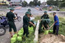 Bộ đội Biên phòng Đà Nẵng giúp dân vận chuyển các bao cát về để chèn mái tôn nhằm ứng phó với bão số 4. (Ảnh: TTXVN phát) 