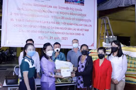Trao quà hỗ trợ cho người Việt và Lào có hoàn cảnh khó khăn do đại dịch COVID-19. (Ảnh: Phạm Kiên/TTXVN)