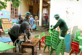 Cán bộ chiến sỹ bộ đội biên phòng Nghệ An cùng giáo viên, phụ huynh học sinh Trường mầm non xã Tà Cạ, huyện Kỳ Sơn, dọn dẹp, vệ sinh, phun tiêu độc khử trùng sẵn sàng đón học sinh trở lại trường sau mưa lũ. (Ảnh: Văn Tý/TTXVN)