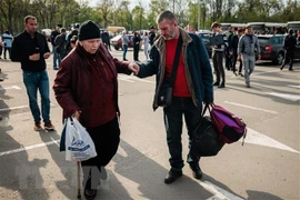 Người dân Ukraine sơ tán từ thành phố Mariupol tới thành phố Zaporizhzhia. (Ảnh: AFP/TTXVN)