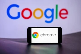 Biểu tượng Chrome trên màn hình điện thoại và biểu tượng Google (phía sau). (Ảnh: Getty Images/TTXVN)