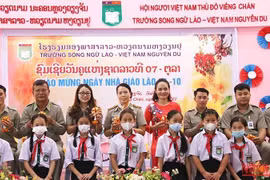 Các em học sinh Trường song ngữ Lào-Việt Nam Nguyễn Du tặng hoa tri ân các thầy, cô giáo nhân Ngày nhà giáo quốc gia Lào. (Ảnh: Hải Tiến) 
