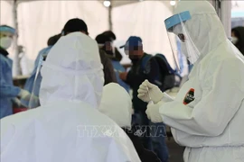 Nhân viên y tế làm việc tại điểm xét nghiệm COVID-19 dã chiến ở Seoul, Hàn Quốc, ngày 26/12/2020. Ảnh: Yonhap/TTXVN 