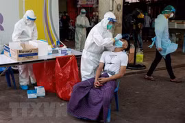 Nhân viên y tế lấy mẫu xét nghiệm COVID-19 cho người dân tại Samut Sakhon, Thái Lan. (Ảnh: AFP/TTXVN) 