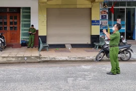 Cơ quan chức năng khám nghiệm hiện trường vụ án. (Ảnh: Nguyễn Thành/TTXVN)
