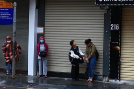 Người dân cảm nhận rõ cái lạnh trong thời tiết mưa, rét sáng. (Ảnh: Hoàng Hiếu/TTXVN)