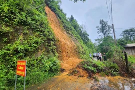 Lãnh đạo huyện Bù Đăng kiểm tra khu vực đồi bị sạt lở ở thị trấn Đức Phong. (Ảnh: TTXVN phát)