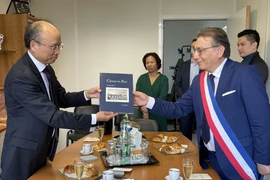 Đại sứ Việt Nam tại Pháp Đinh Toàn Thắng và thị trưởng thành phố Choisy-le-Roi, trao quà lưu niệm. (Ảnh: Nguyễn Thu Hà/TTXVN)