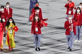 Đoàn thể thao Việt Nam diễu hành tại lễ khai mạc Olympic Tokyo 2020 trên sân vận động Olympic ở Tokyo (Nhật Bản), ngày 23/7/2021. (Ảnh: AFP/TTXVN) 