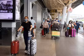 Hành khách di chuyển đến nhà ga trong nước để về quê đón Tết Nguyên đán 2021. (Ảnh: Tiến Lực - TTXVN)