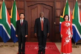 Đại sứ Hoàng Văn Lợi và phu nhân chụp ảnh cùng Tổng thống Nam Phi Cyril Ramaphosa. (Ảnh: Phi Hùng/Phóng viên TTXVN tại Nam Phi)