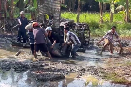 Người dân địa phương đến ứng cứu, tuy nhiên nạn nhân đã tử vong trước đó. (Ảnh: TTXVN phát)