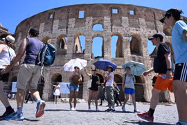 Khách du lịch che ô tránh nắng nóng khi tham quan Đấu trường La Mã ở Rome, Italy ngày 12/7/2024. (Ảnh: THX/TTXVN)