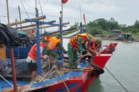 Chính quyền xã Vĩnh Trung (TP Móng Cái) phối hợp với Đồn Biên phòng cửa khẩu cảng Vạn Gia cùng nhân dân cố định, neo đậu tàu, thuyền tránh bão số 2. (Ảnh: TTXVN phát)