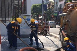 Nhân viên Công ty TNHH MTV Thoát nước Hà Nội kiểm tra, nạo vét hệ thống ga cống trước thời điểm bão số 3 đổ bộ đất liền. (Ảnh: TTXVN phát)