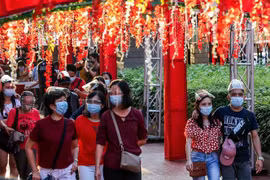 Người dân đeo khẩu trang phòng lây nhiễm COVID-19 trong kỳ nghỉ lễ Nguyên đán. (Ảnh: THX/ TTXVN)
