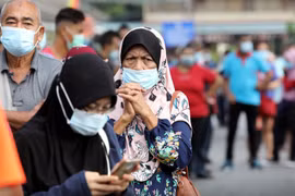 Người dân xếp hàng chờ làm xét nghiệm tại TP Klang, Malaysia. (Ảnh: Reuters)