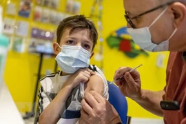 Nhân viên y tế tiêm vaccine phòng COVID-19 của Pfizer/BioNTech cho trẻ em tại Berlin, Đức (Ảnh: AFP/TTXVN)