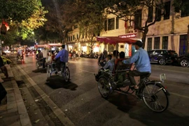 Nhiều gia đình ngắm phố phường Hà Nội trên những chuyến xích lô. (Ảnh: Tuấn Anh/TTXVN)